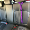 The adjustable pet car seat belt in purple attached to a car seat.