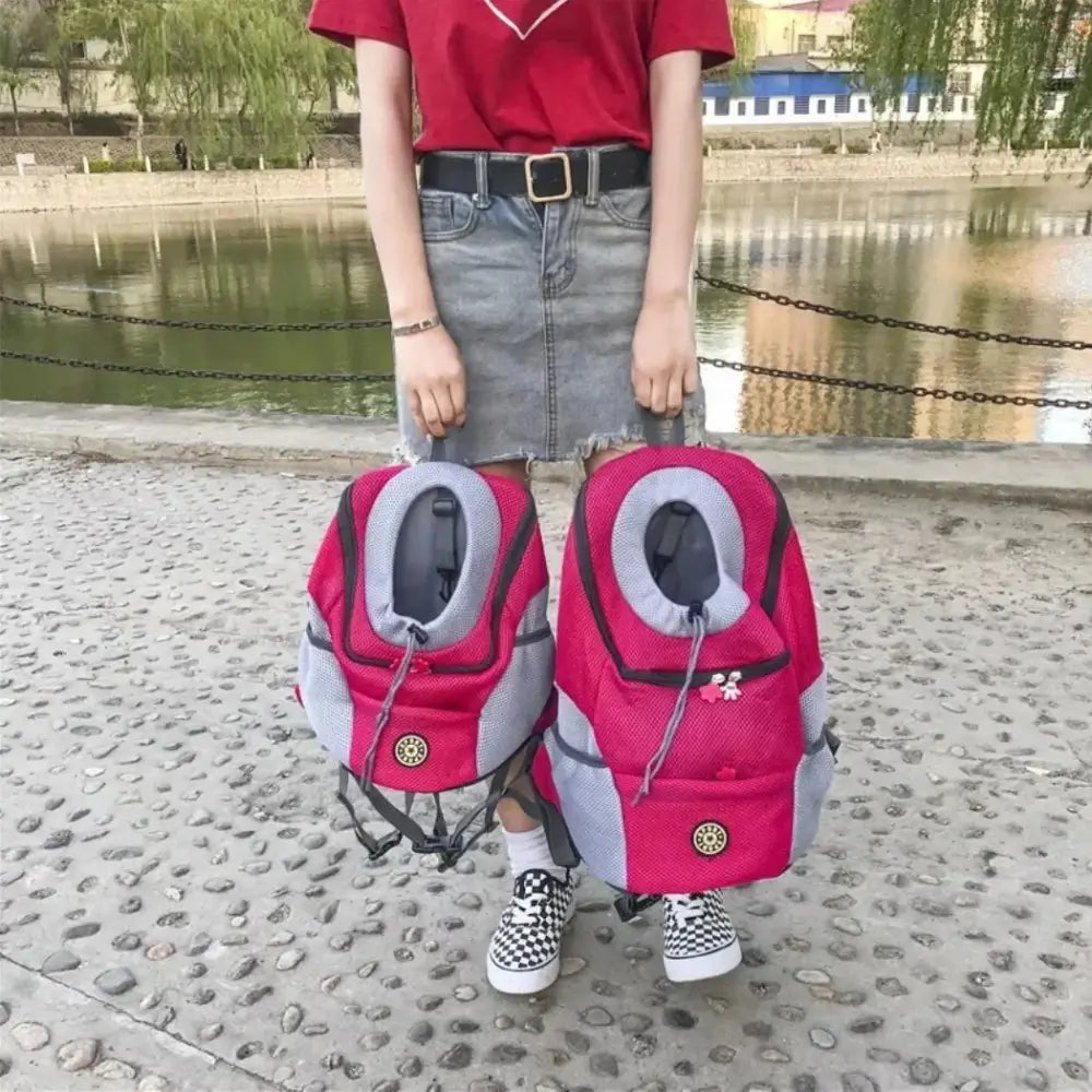 A woman holding 2 of the outdoor portable pet backpacks in 2 different sizes.