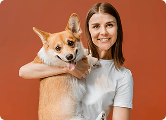 Happy woman holding a Corgi dog